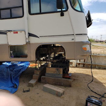 An RV up on blocks in a backyard being repaired by MechaMedix traveling RV